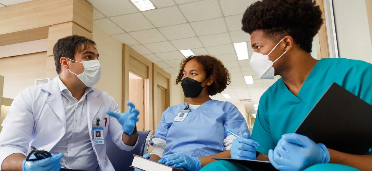 two nursing assistants with their clinical instructor at CNA class